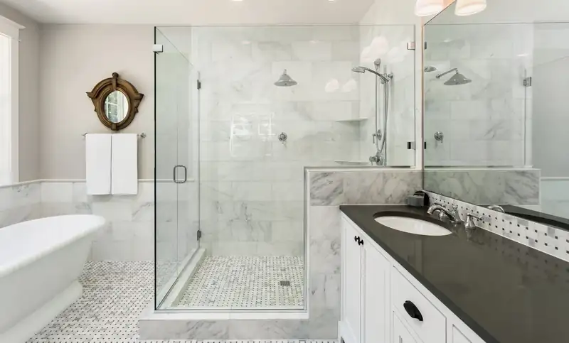 Custom frameless glass shower in a luxury marble bathroom in Vancouver