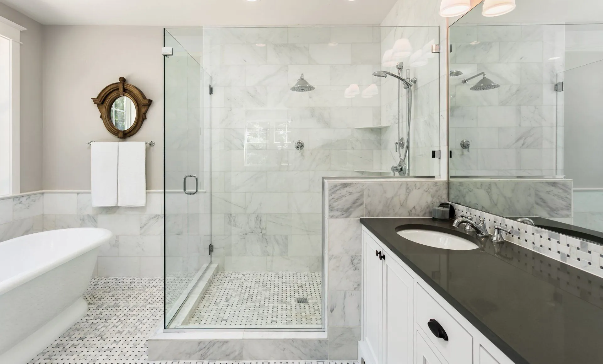 Frameless shower enclosure in a marble bathroom in Burnaby