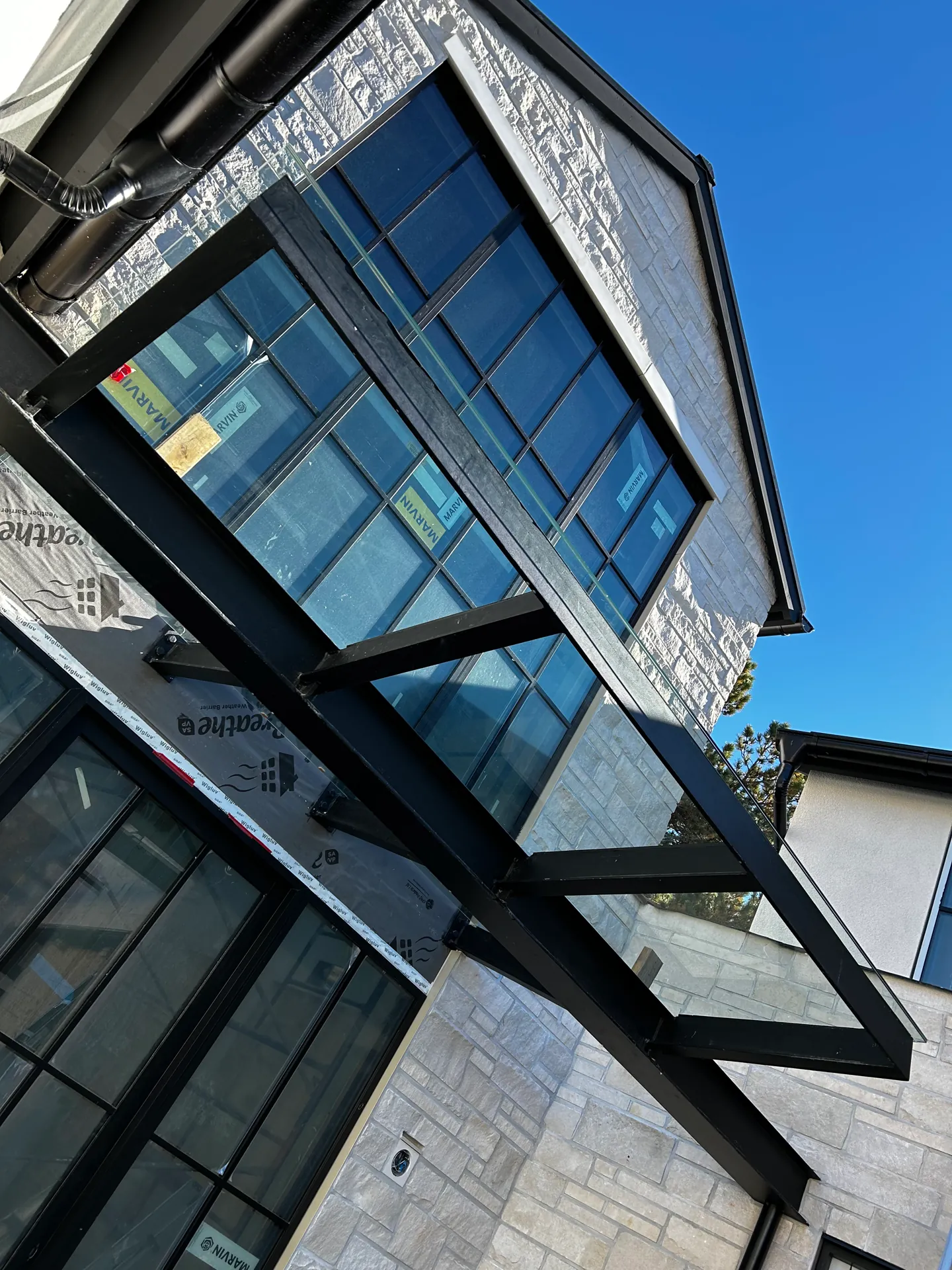 Modern stone facade with black window system in North Vancouver